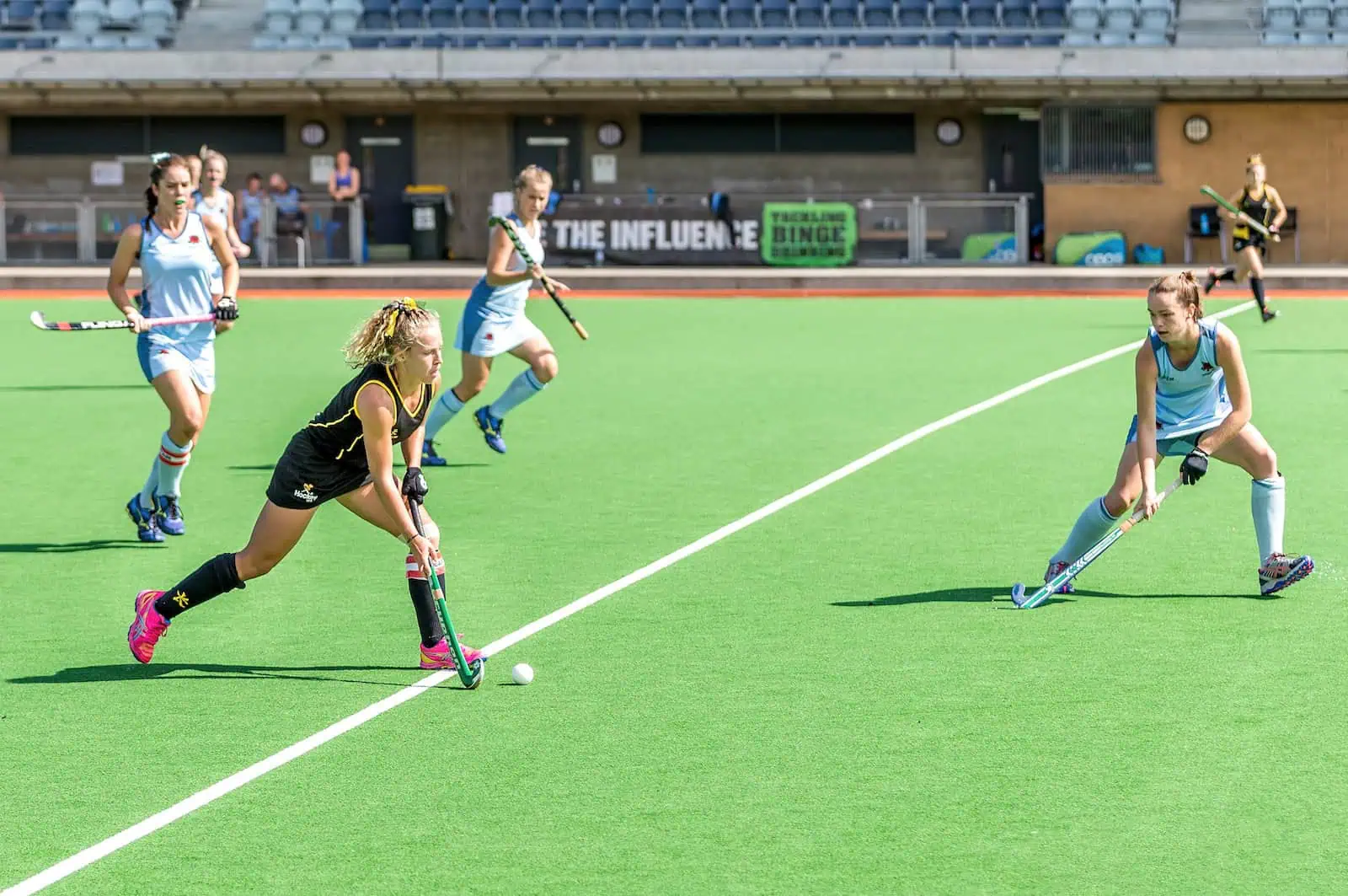 woman wearing black jersey playing field hockey