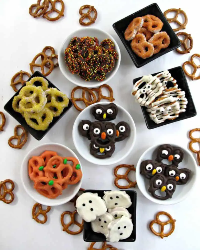 Many bowls filled with chocolate covered pretzels made to look like owls, mummies, ghosts, and pumpkins.
