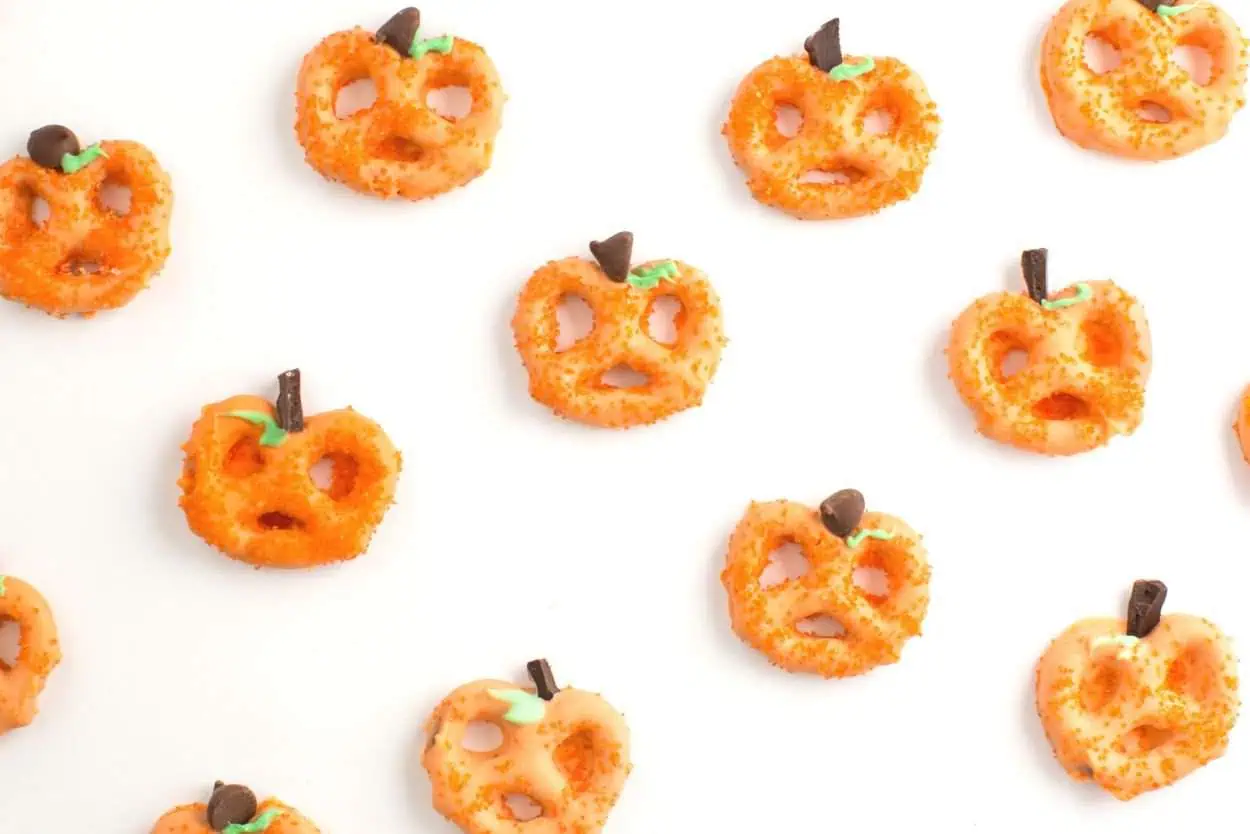Pretzels dipped in orange white chocolate and made to look like pumpkins