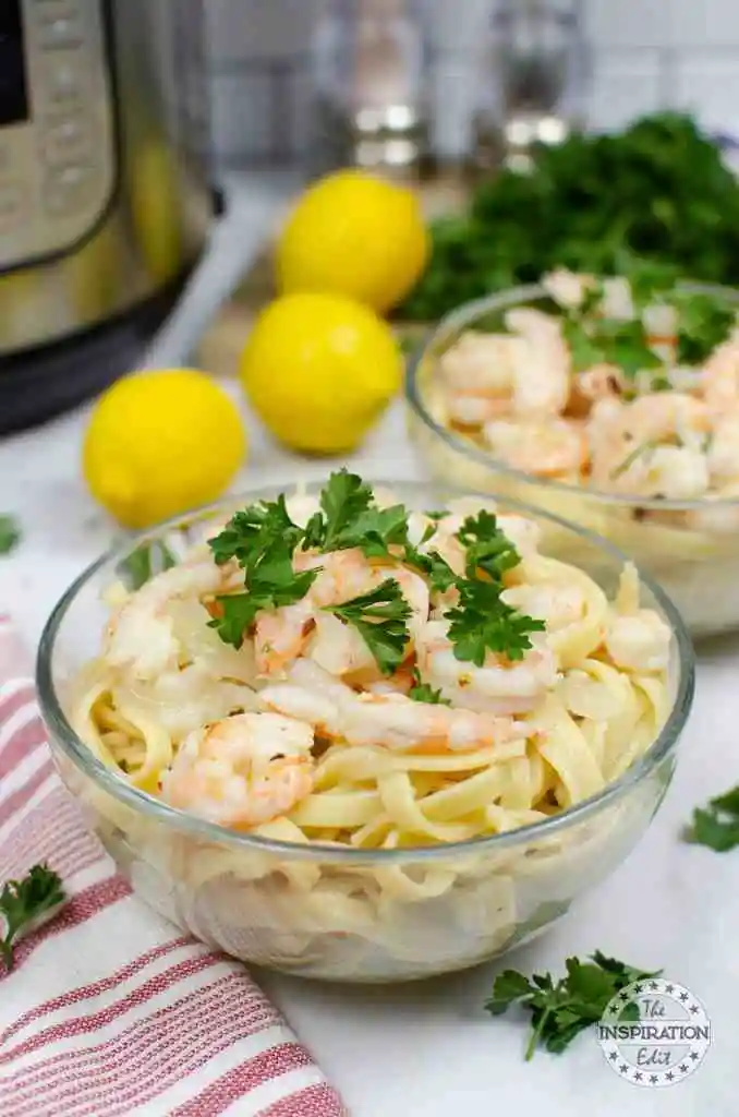 Shrimp scampi recipe with instant pot, lemons, and herbs in the background.