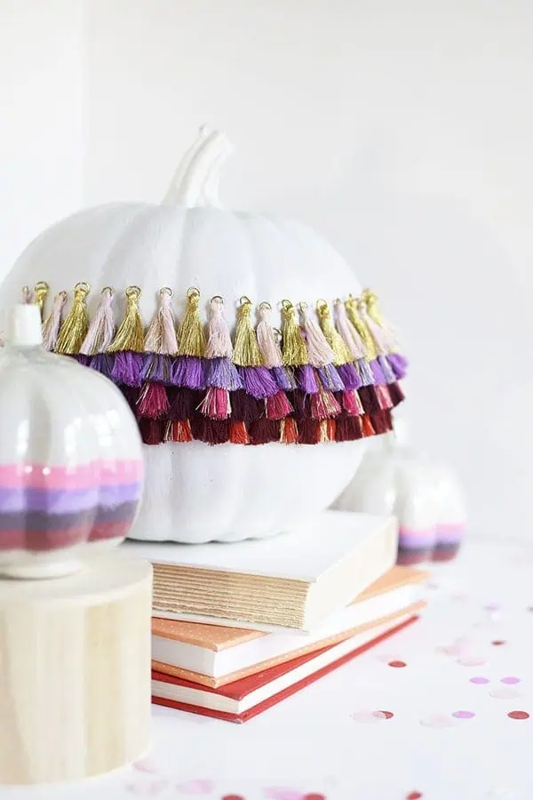 Delineate Your Dwelling: white pumpkin with tassel and ruffle fringe wrapped round its waist band.