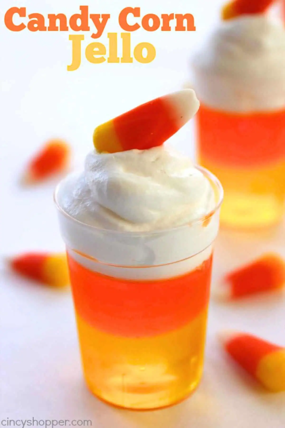 Candy corn themed jello cup with orange and yellow jello, topped with whipped cream for a delicious fall snack