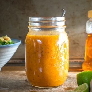 chipotle honey vinaigrette in jar with lime and salad