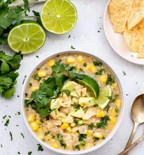 crockpot white chicken chili in a white bowl with slices of lime