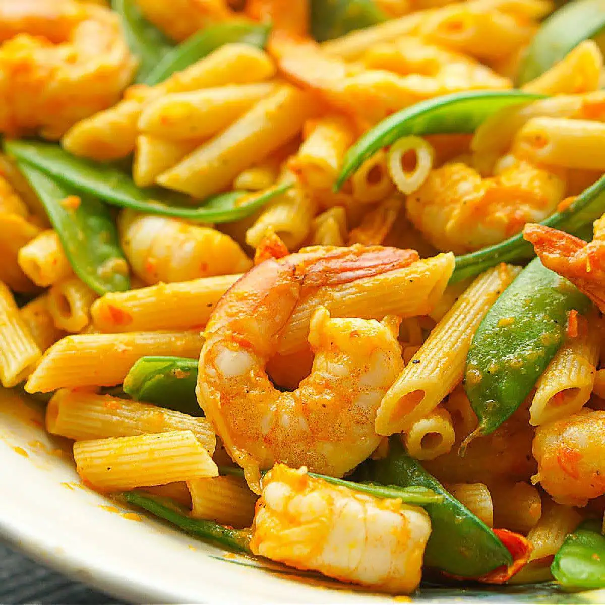 Close up of shrimp pepper pasta with snow peas.