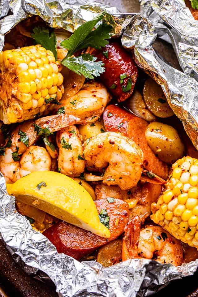 A variety of colorful and delicious foil packets for the oven featuring chicken foil packets, vegetable foil packets, and seafood foil packets in aluminum foil.