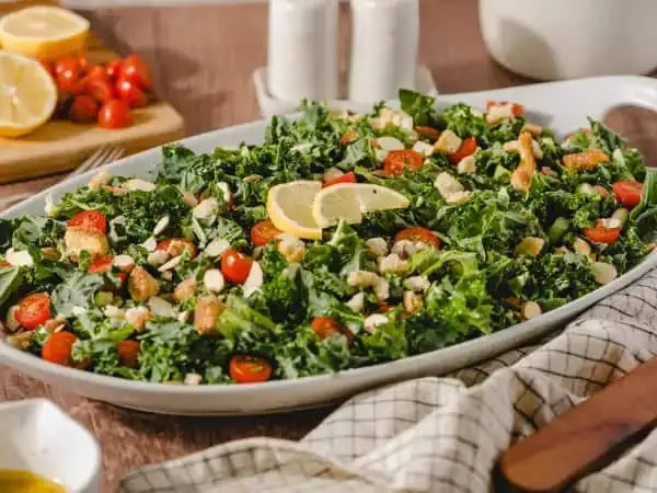 image 1069 - Make everyone happy with this one-bowl wonder! Crowd-Pleaser Kale Salad is an incredibly appealing dish for any occasion. There will be crunches for days with this combo of fresh kale, slivered almonds, grated parmesan, and juicy grape tomatoes, tossed with a honey-mustard-lemon dressing and some amazing croutons. It creates a full, robust, salad sensation. Be the Crowd-Pleaser Kale Salad courier to all your special gatherings. Come on and join the crowd!