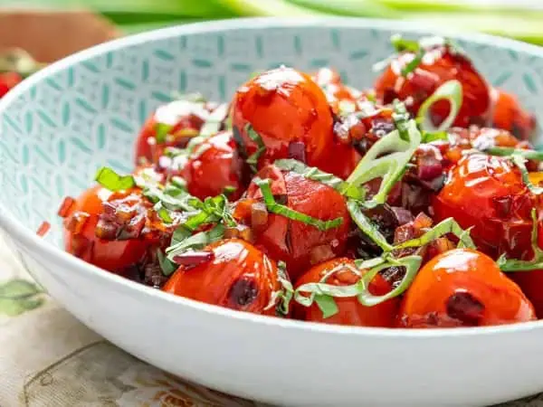 image 13624 - This might be one of the best side dishes we've ever seen, and the fact that it's so easy and fast to make? That's just the cherry (tomato) on top! Blistered Tomatoes sauté bright, juicy tomatoes until softened and sweetened, pairing the vibrancy with tangy vinegar and savory red onion for an exquisite balance of flavors. It's warm, summery, filling, and so, so enticing... something you may not expect from a vegetarian dish! Blistered Tomatoes will become a go-to in your house, no question about it!