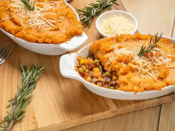 image 15188 - Everything really should be dressed up fancy to embrace the holidays, even your dinner! A few quick changes to your traditional Shepard's pie will transform it into this Holiday Shepherd's Pie, a fantastically festive flavor fountain! Caramel-y sweet potatoes mingle with rich butter and sharp parmesan for a wonderfully creamy and fluffy top, nestled atop a succulent pork sausage and sunny corn mixture, brightened with tomatoes and other garden veggies. You might actually feel a little underdressed sitting next to Holiday Shepherd's Pie this year!