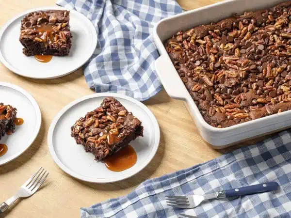 image 17957 - Why not take a swim in a sea of sweetness with this Turtle Dump Cake? The rivers of caramel, the waves of deep, floral, smooth chocolate, the crunch of the pecans, all atop a delicious chocolate cake. It's as indulgent as its namesake candies and really quite simple to make. You "shell" love digging into this Turtle Dump Cake! Sorry, we're just so giddy about it we couldn't resist the pun!