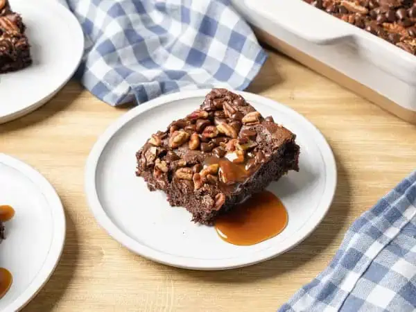 image 17961 - Why not take a swim in a sea of sweetness with this Turtle Dump Cake? The rivers of caramel, the waves of deep, floral, smooth chocolate, the crunch of the pecans, all atop a delicious chocolate cake. It's as indulgent as its namesake candies and really quite simple to make. You "shell" love digging into this Turtle Dump Cake! Sorry, we're just so giddy about it we couldn't resist the pun!