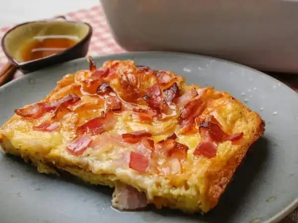 image 18657 - What's your ideal way to spend your morning? With a cup of coffee and a good book maybe? Going for a sunrise stroll? Sleeping in? Ours just happens to be enjoying this Perfect-Combo Breakfast Bake. The tender, fluffy bread sprinkled with melty cheese, salty bacon, and a drizzle of thick and rich maple syrup is the sweet-and-salty concoction our tastebuds crave as we wake up. We think you should add this Perfect-Combo Breakfast Bake to your favorite morning routine... we know it'll make it even better!