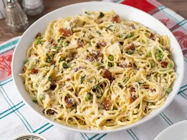 image 3478 - Ah, Authentic Pasta Carbonara! Can't you just hear that zippity, classic Italian jazz playing already? If not, you should definitely crank it up as you whip together this bouncy pasta that's twirled with fresh peas, crispy bacon, and salty Parmigiano-Reggiano with a citrusy hint. It's light yet filling and will certainly have you dancing to a new beat. So, get in the spirit, pour yourself a glass of something sparkling, and enjoy scooping up this Authentic Pasta Carbonara!