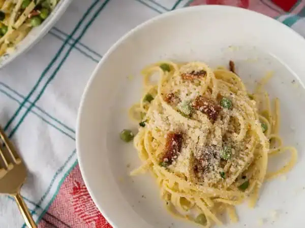 image 3479 - Ah, Authentic Pasta Carbonara! Can't you just hear that zippity, classic Italian jazz playing already? If not, you should definitely crank it up as you whip together this bouncy pasta that's twirled with fresh peas, crispy bacon, and salty Parmigiano-Reggiano with a citrusy hint. It's light yet filling and will certainly have you dancing to a new beat. So, get in the spirit, pour yourself a glass of something sparkling, and enjoy scooping up this Authentic Pasta Carbonara!