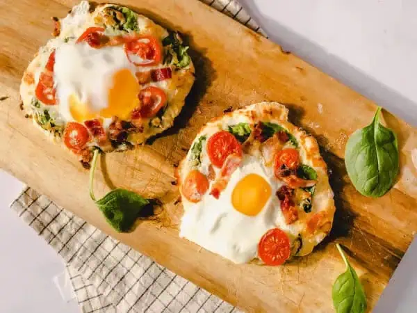 image 7931 - Hit the snooze button on boring breakfast fare! Snoozefest Pizza will have you up and at 'em to start the day off right! A super easy, homemade crust is quickly put together, then topped with baby spinach, mozzarella cheese, cherry tomatoes, an egg, and some savory bacon pieces for the breakfast of (wide-awake) champions! Don't sleep on this one, Snoozefest Pizza will reawaken your love for a great breakfast. And overnight your whole family will become morning people again! You snooze, you lose!