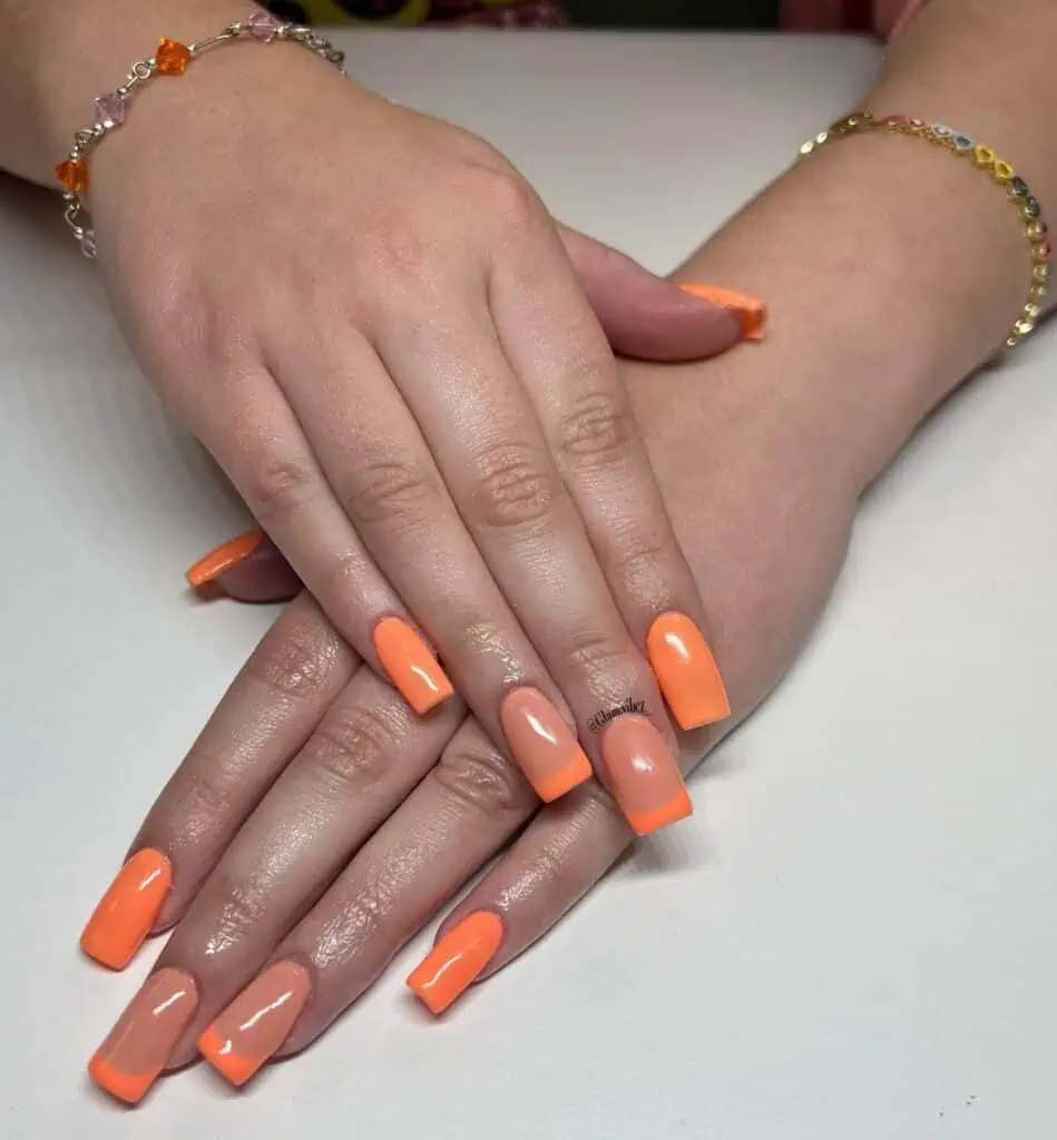 Chic summer nails featuring vibrant orange hues, from neon to burnt with glitter accents, perfect for adding a seasonal touch.