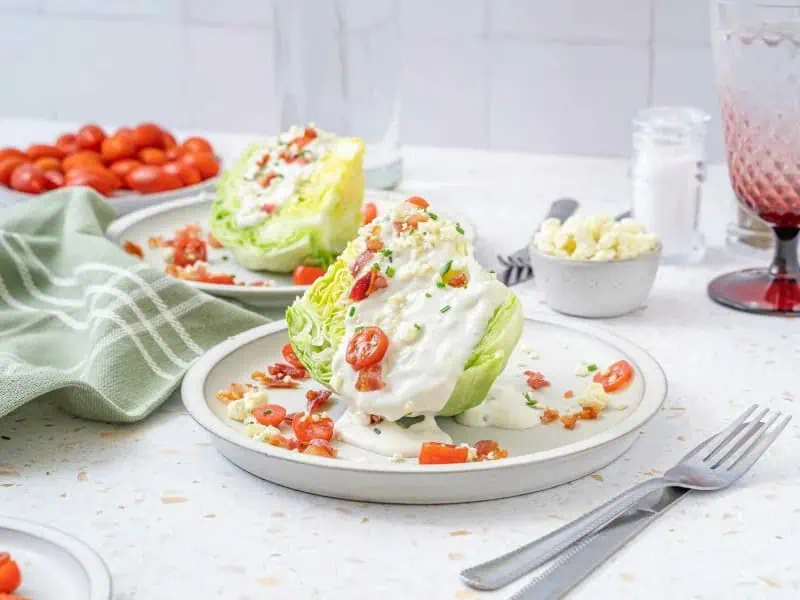 image 247 104 - Classic Wedge Salad sounds so fancy, but here's a little secret... "fancy" isn't always synonymous with "challenging" in the kitchen! It's as simple as a wedge of crispy iceberg lettuce, a drizzle of creamy blue cheese dressing, and a sprinkle of salty bacon, sweet tomatoes, oniony chives, and rich blue cheese crumbles. And just to clarify, simple doesn't mean any flavor is lacking! Classic Wedge Salad is your go-to when you only have a little time, but still want to impress!