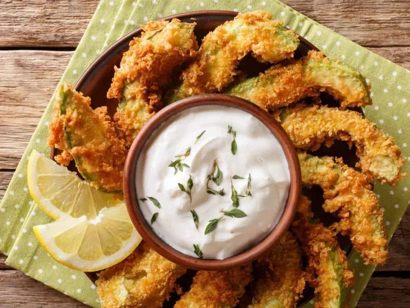 image 247 128 - Fried Avocados is a delicious app or snack that consists of freshly sliced avocado that is breaded and fried! This dish is crispy on the outside and creamy in the middle. Fried Avocados can be served with sour cream and salsa for a yummy party treat or a snack for a night in! French fries might want to take notes!