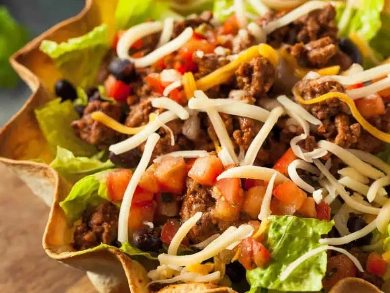 image 247 56 - Everyone loves an Easy Taco Salad, loaded with spicy, juicy ground beef and Mexican seasonings. When piled atop chilled lettuce and mixed with sharp cheese and savory beans, Easy Taco Salad is a flavorful, colorful dish perfect as a side dish or as the main course for a speedy weekday dinner. You can customize it to make the taco salad of your dreams, whether that be tangy, creamy, or spicy!