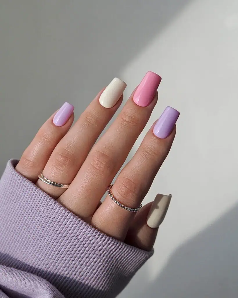 A selection of nails in soft pink, blue, and green tones, highlighting charming spring pastel designs.